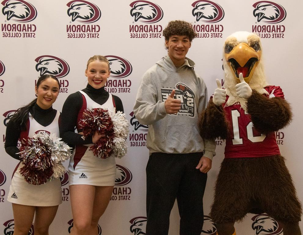 Three students posing with eagle mascot